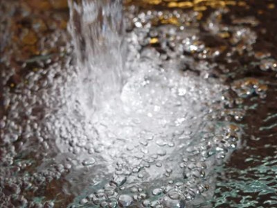 Water splashing onto a surface with bubbles forming.