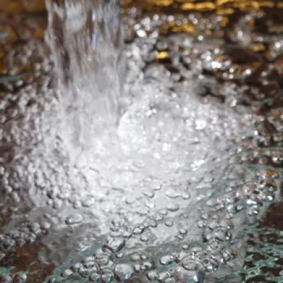 Water splashing on a reflective surface with bubbles
