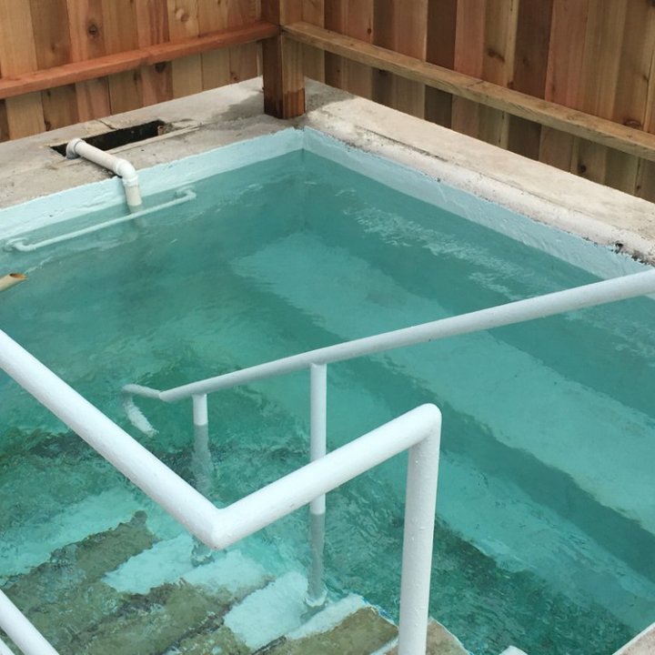 Small, empty rectangular pool with steps and a handrail.